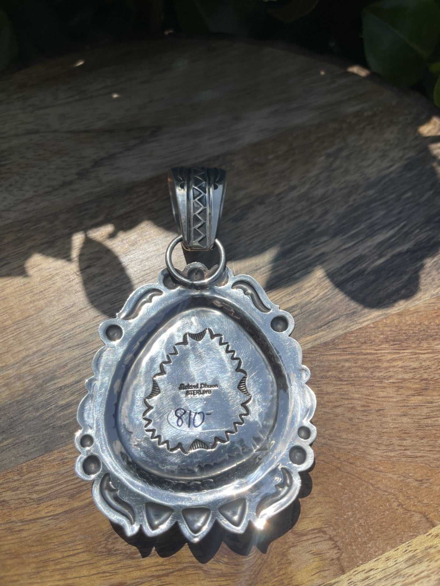 Native American Kingman turquoise pendant by Roland Dixon with intricate silver design and stamped back.