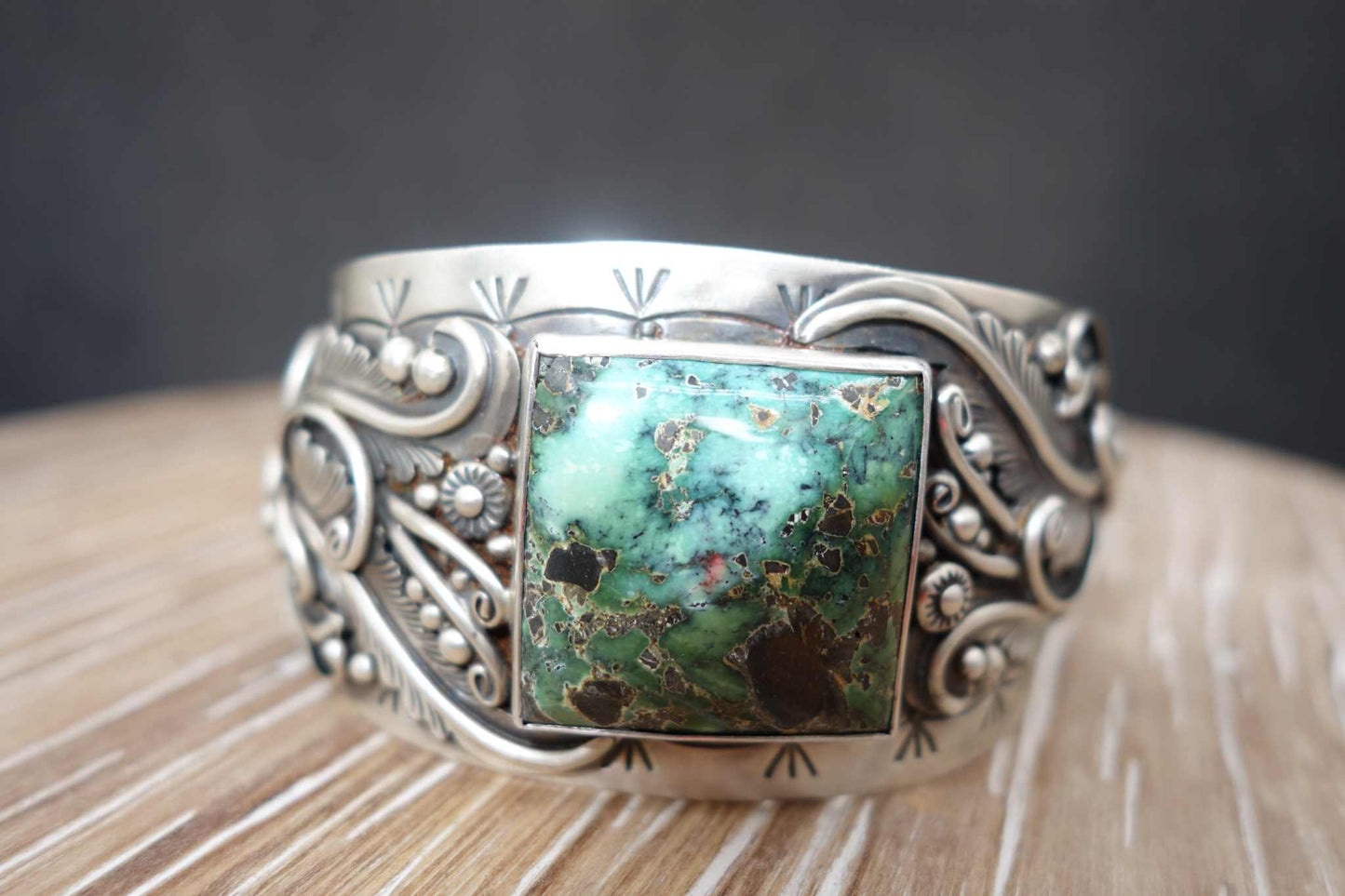 Sterling silver cuff with a square green Blue Moon turquoise stone and intricate designs.