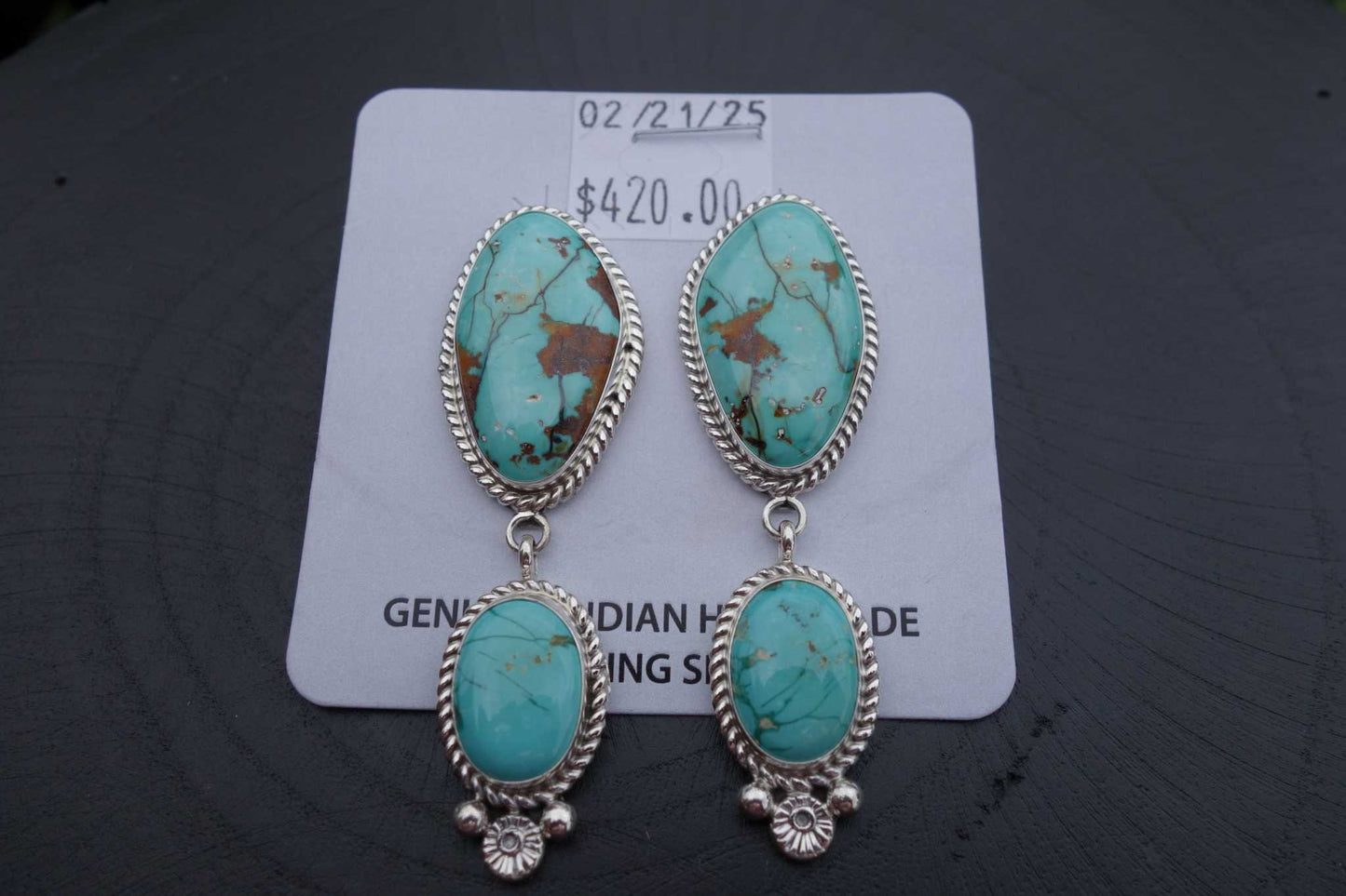 Royston Turquoise Earrings with silver setting and brown matrix made by Navajo artist displayed on price card