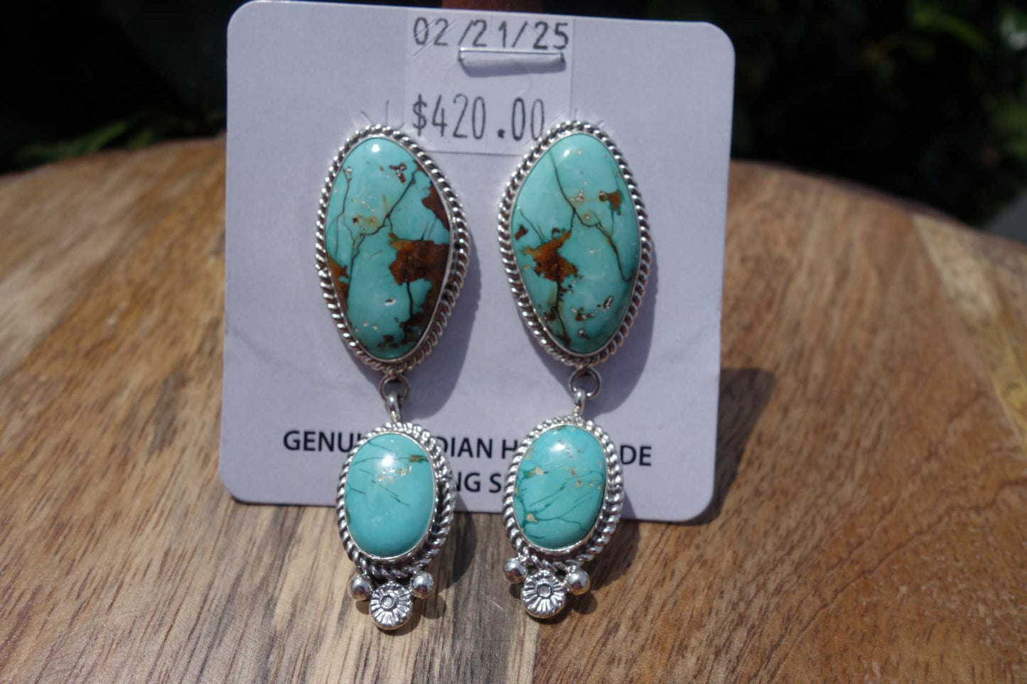 Pair of Native American handmade Royston Turquoise Earrings with silver setting and brown matrix details.