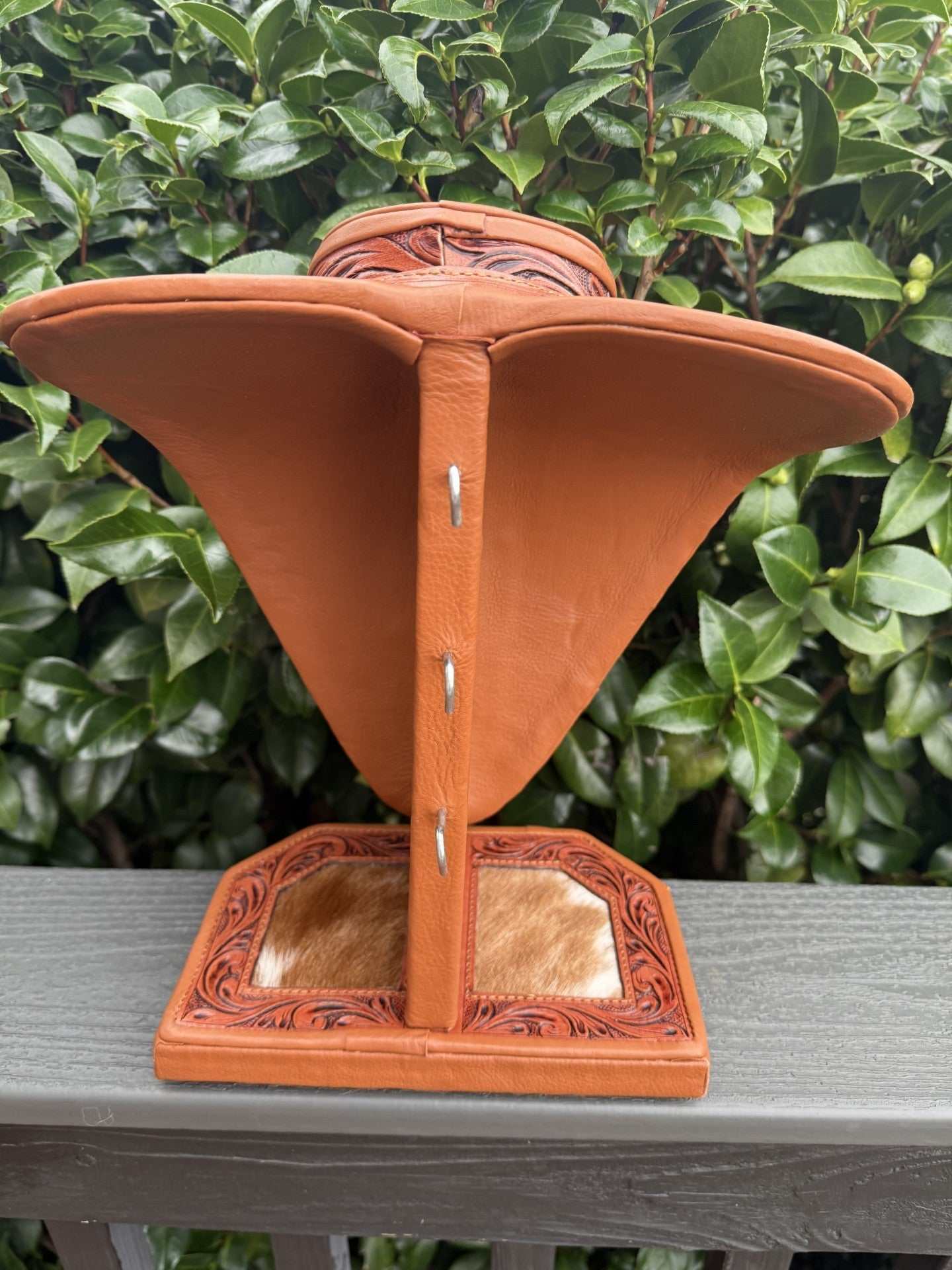 Tan tooled leather and white cowhide necklace display stand for jewelry showcase