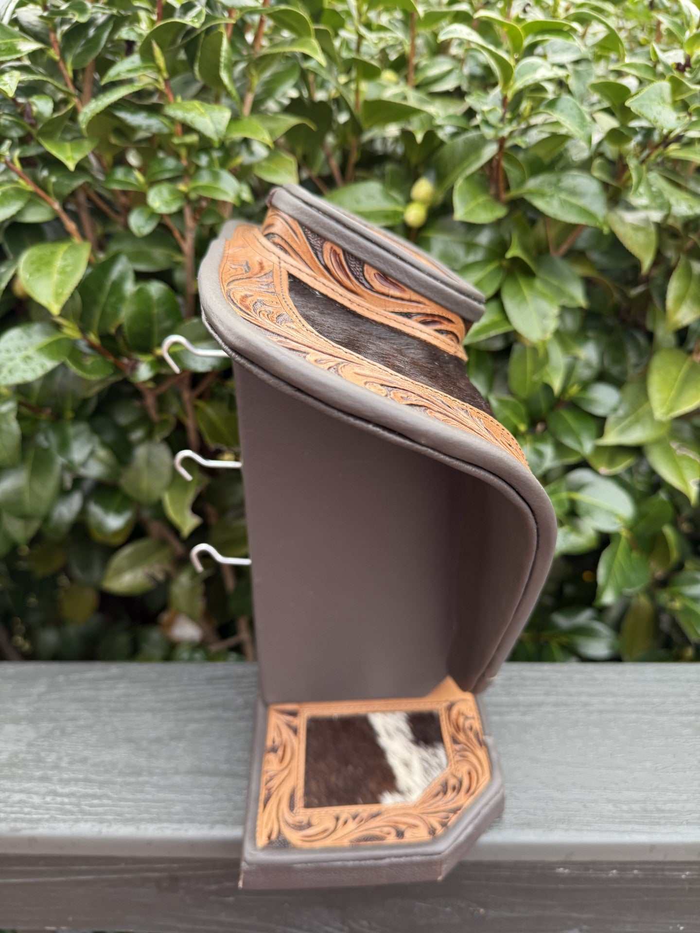 Dark and light brown tooled leather and black and white cowhide necklace display stand