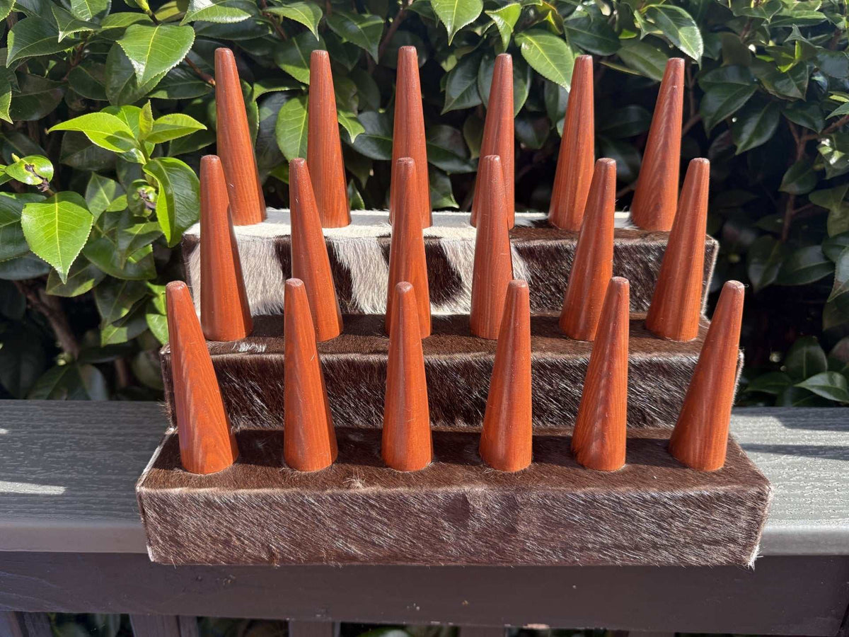 18 Finger Cowhide ring holder in brown and white cowhide with polished wooden pegs arranged in rows