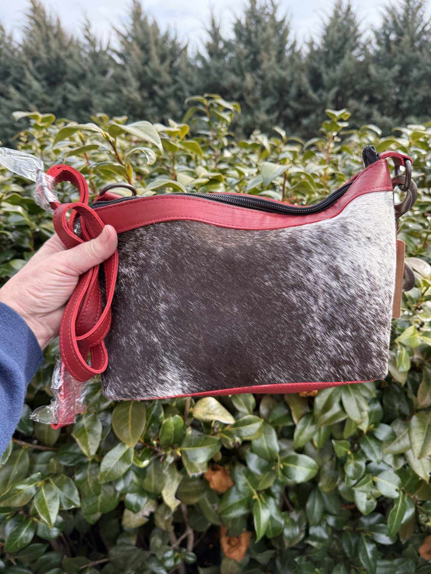 Red leather and cowhide purse with metal handle and natural cowhide patterns