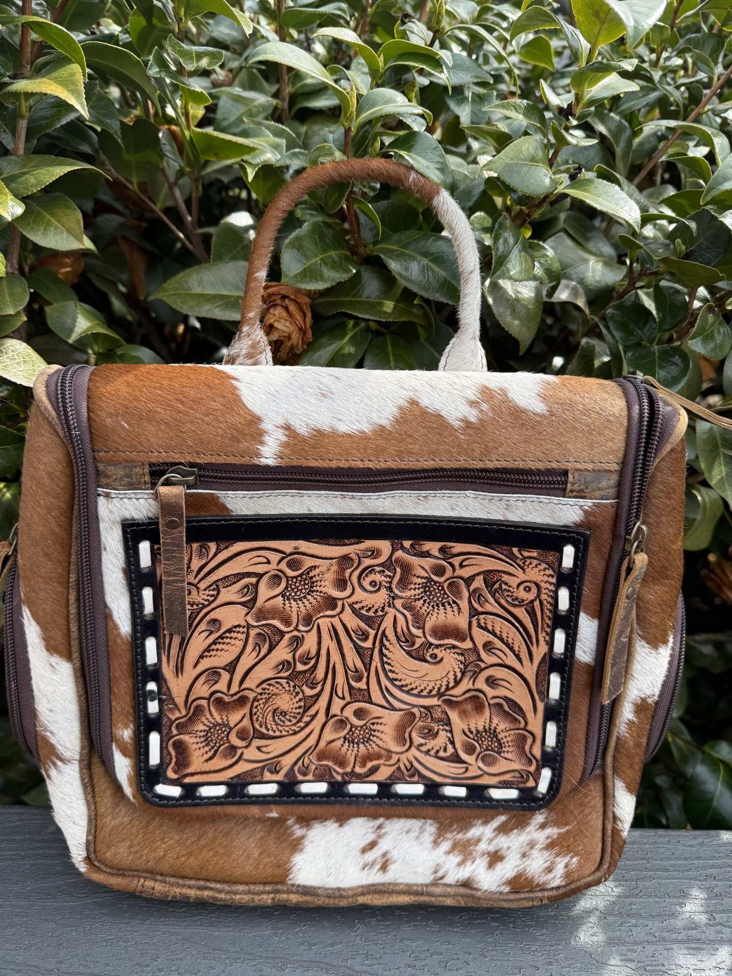 Tooled & cowhide hanging toiletry bag with hand-tooled leather and sturdy hanging hook for travel and gym organization
