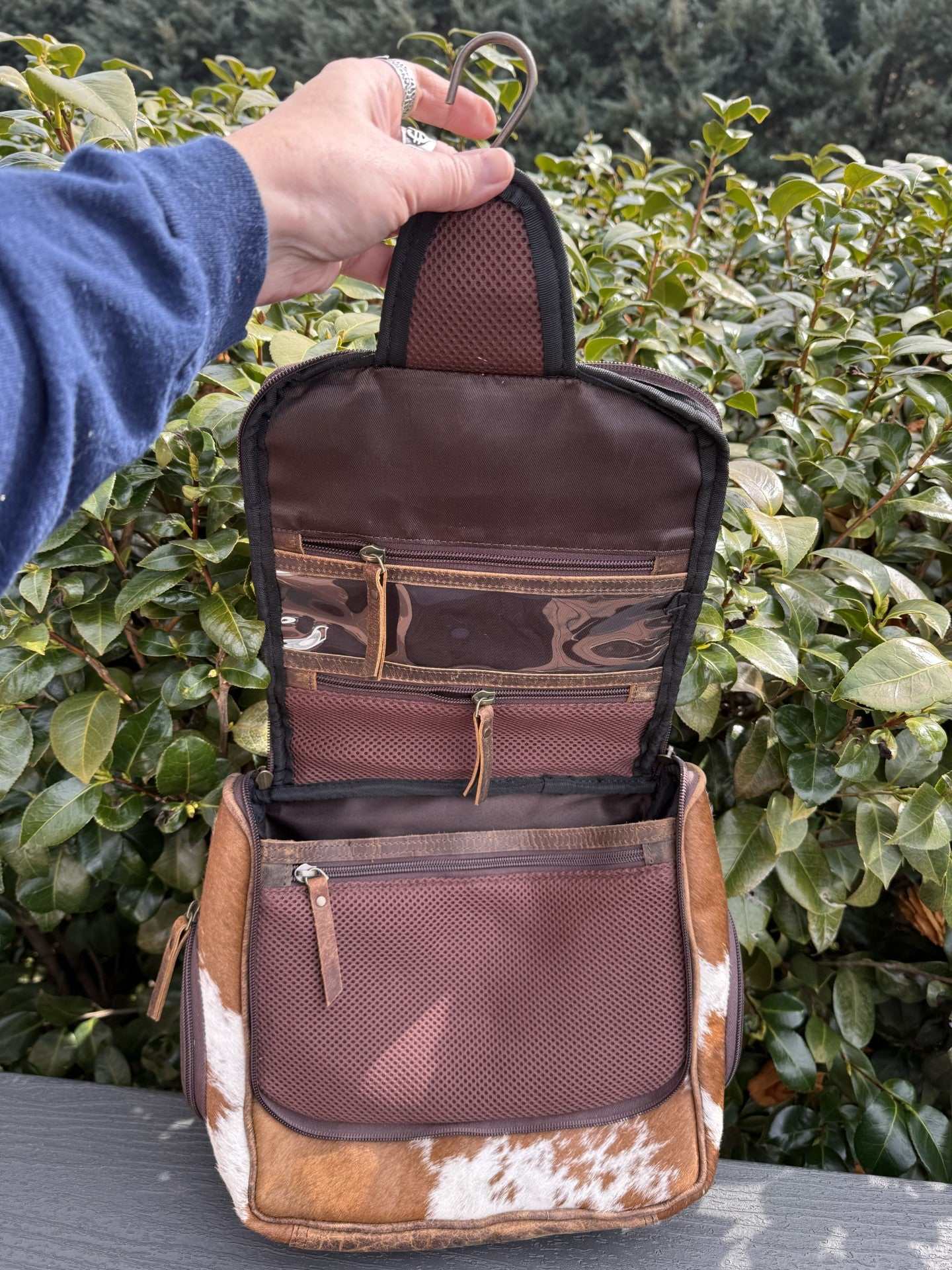 Tooled & cowhide hanging toiletry bag with hand-tooled leather and natural cowhide, hanging hook, and multiple compartments for travel and gym organization