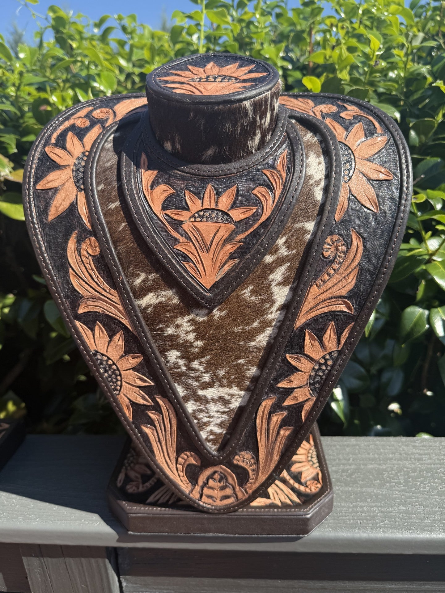 necklace display with hand tooled black and tan leather and cowhide