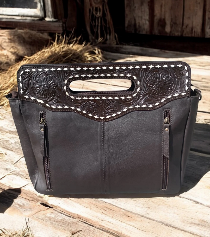 Handcrafted tooled leather crossbody purse with intricate designs and spacious interior.