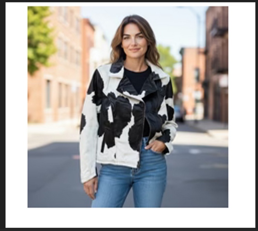 Woman wearing black and white cowhide jacket with fringe in size XL outdoors