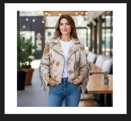 Tan cowhide jacket with fringe worn by woman with blue jeans in casual setting