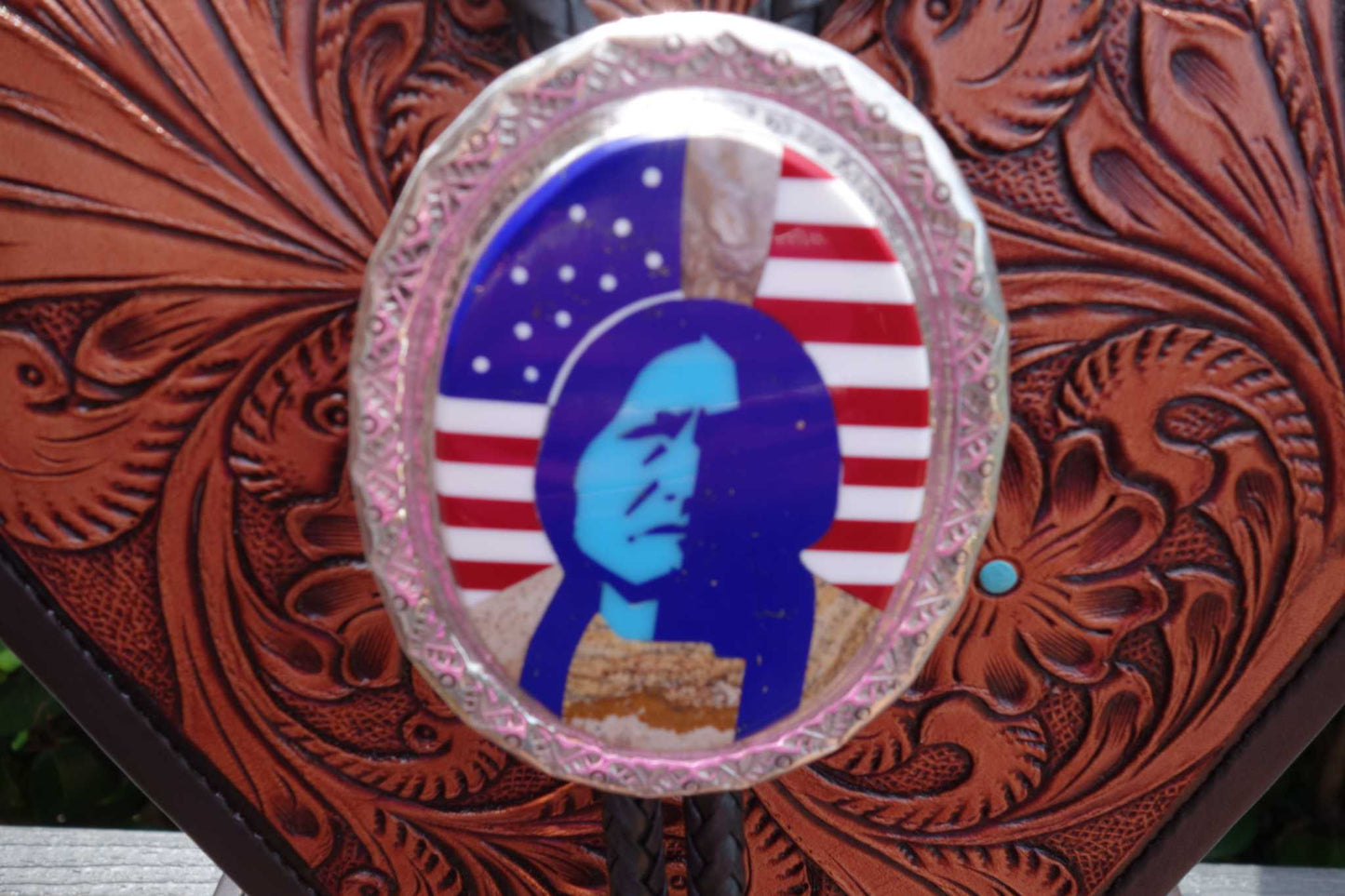 Calvin Desson silver Navajo bolo with Sitting Bull inlay design, featuring turquoise and various stones.
