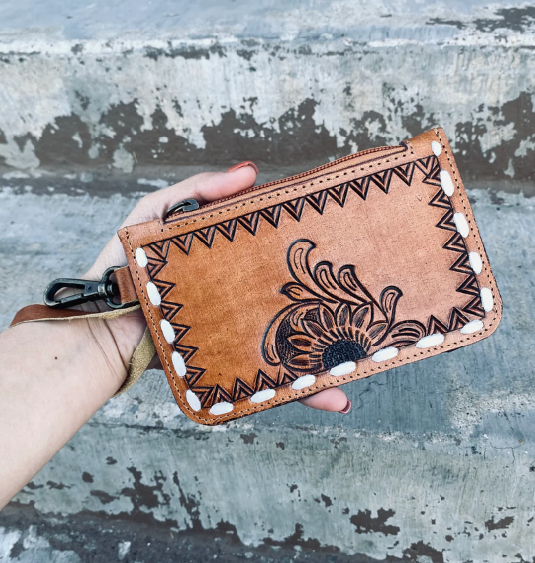 Flower tooled wristlet pouch with hand-tooled floral design and soft leather back.