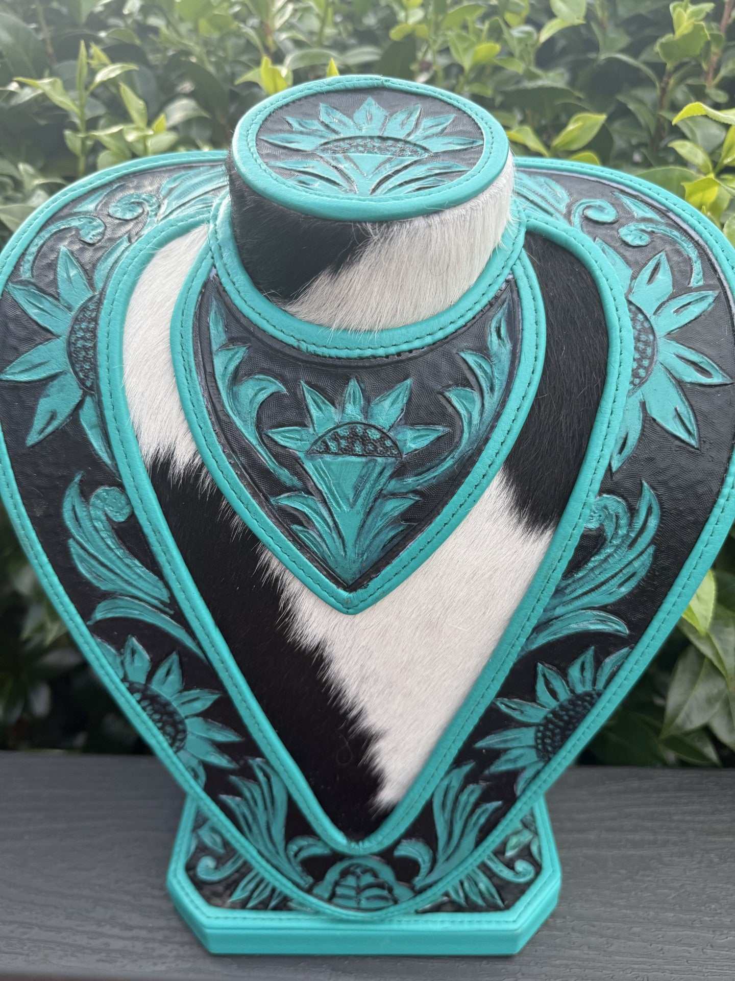 Hand tooled green turquoise and black leather necklace display with cowhide accents