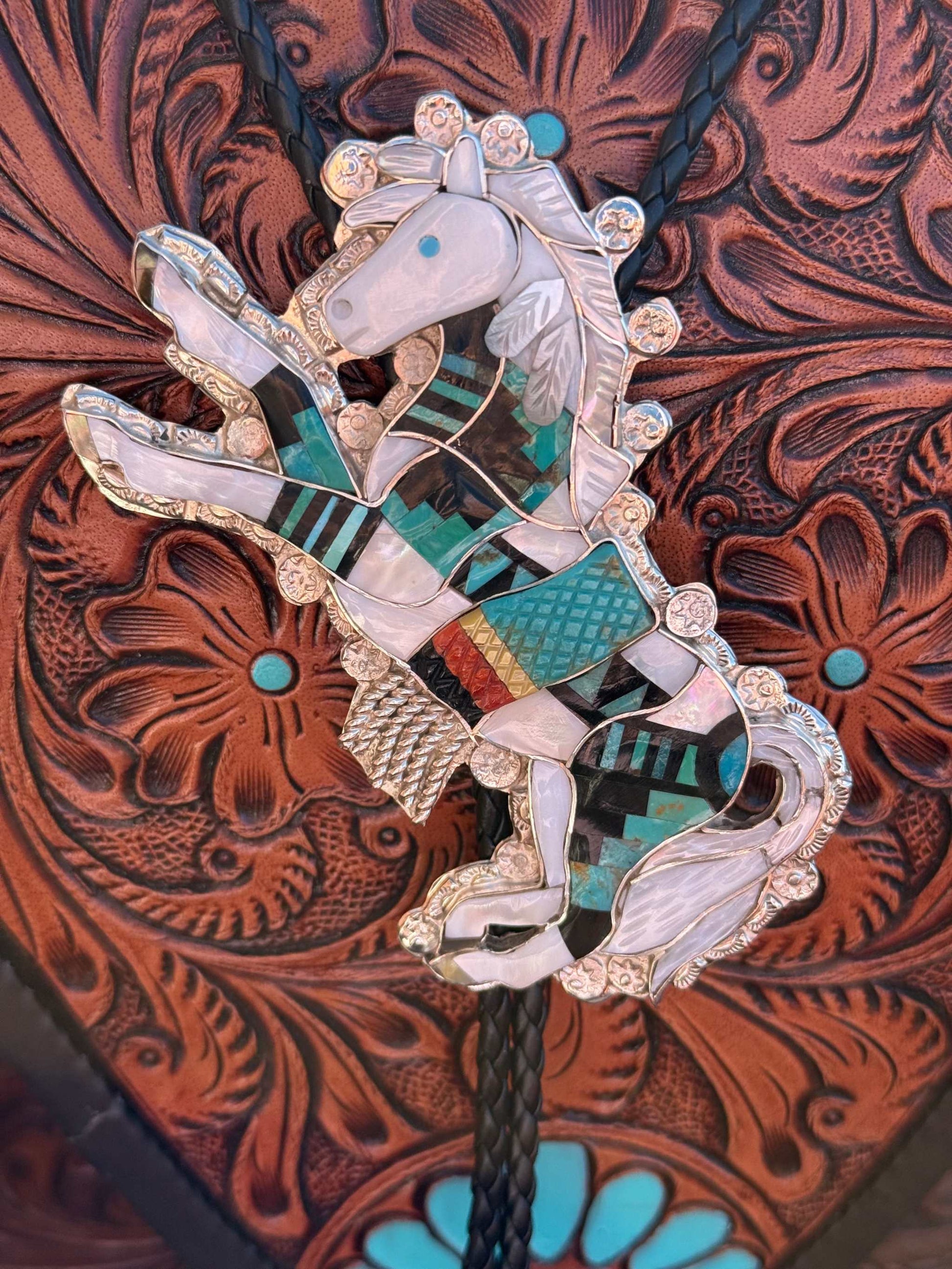 Eldred Martinez Horse Bolo with multi stone inlay and intricate silver design on leather background