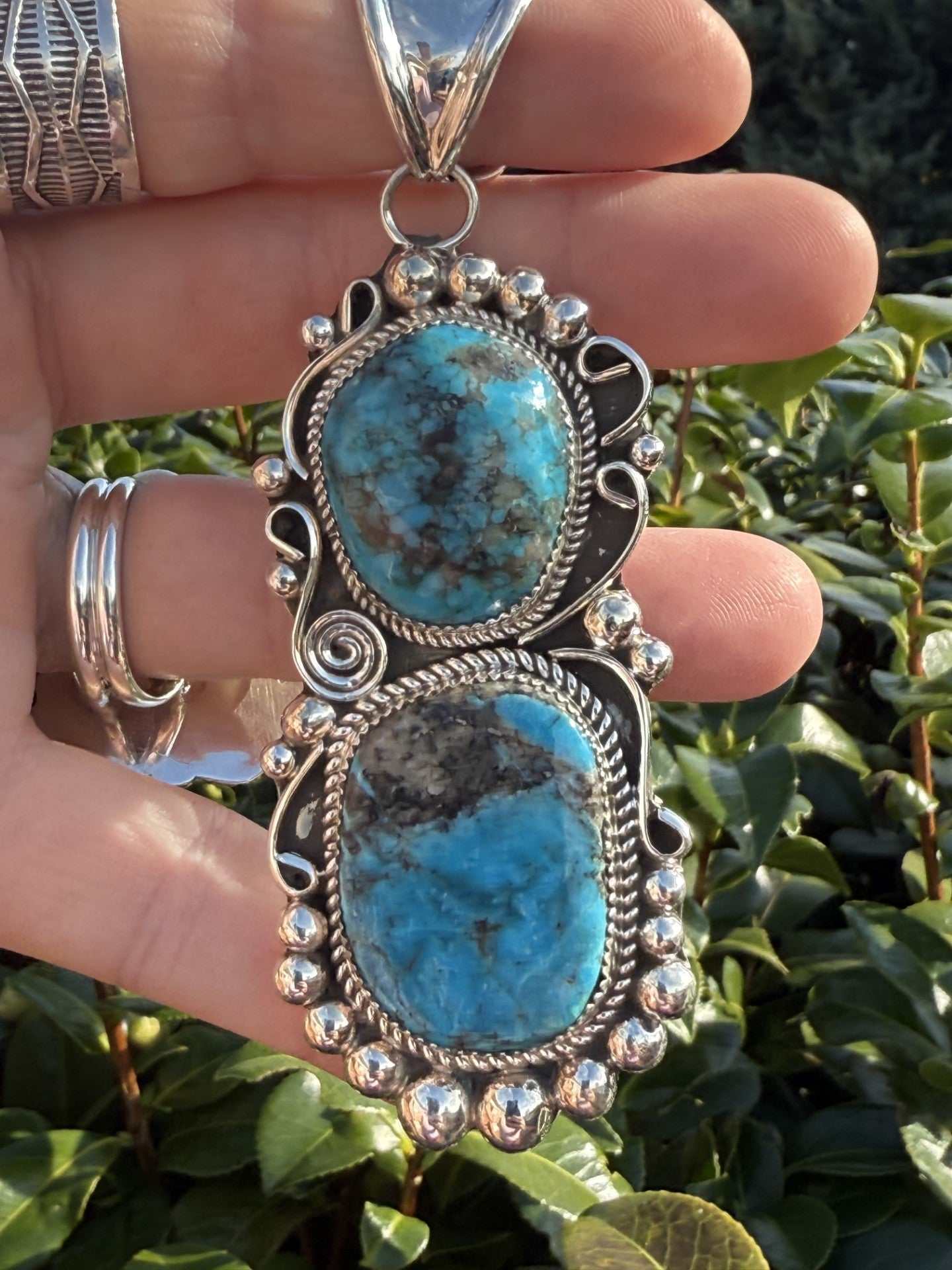 Kingman Turquoise Pendant by Ray Nez with two blue turquoise stones and silver detailing