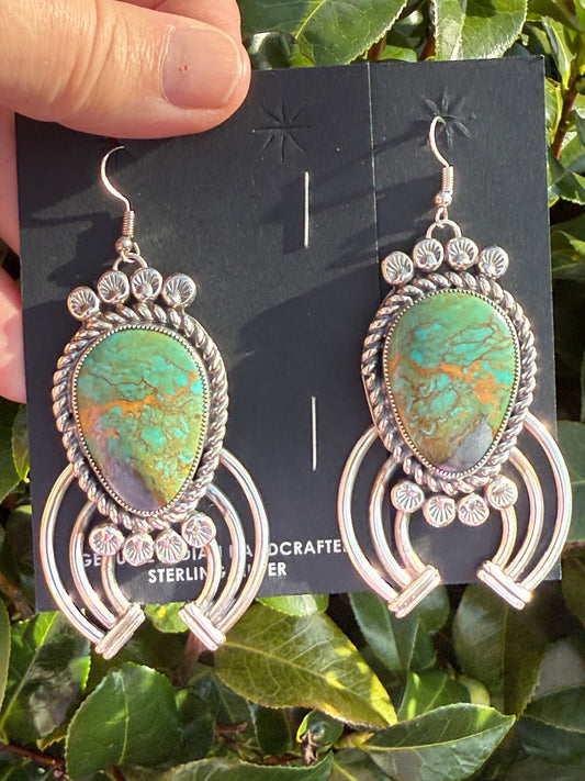 Royston Turquoise earrings with intricate silver design by Navajo artist Limbert Perry, featuring large oval turquoise stones on ornate silver hooks.