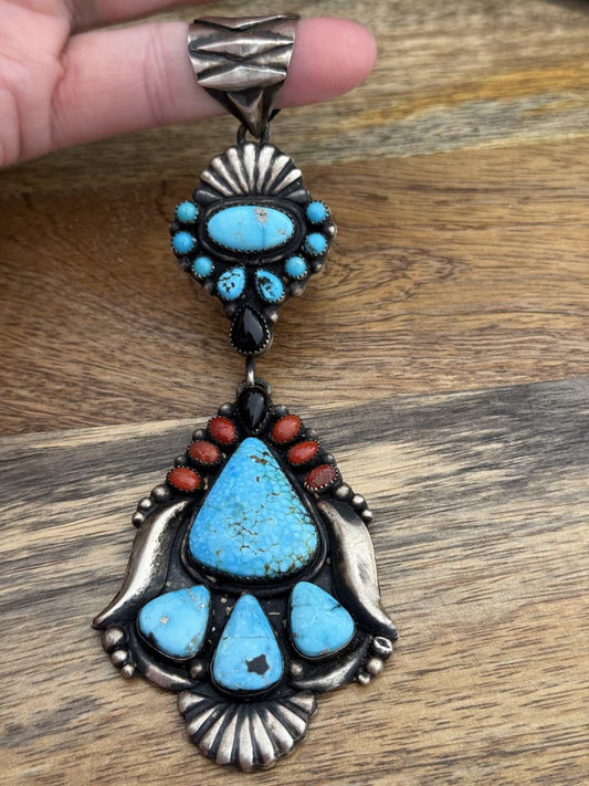 Multi stone pendant with turquoise, black onyx, and coral by Shawn Cayatineto on wooden background