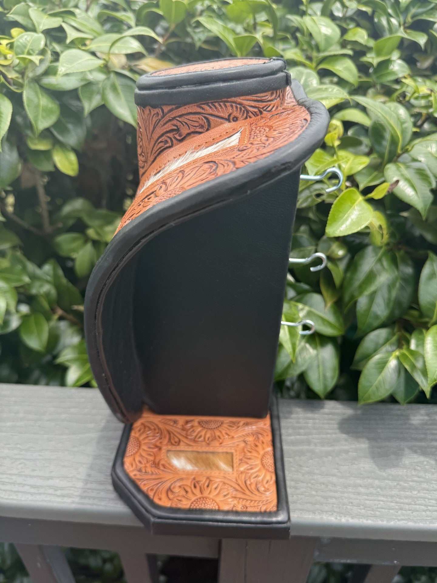 Medium tan brown tooled leather necklace display with brown and white cowhide for stylish jewelry organization