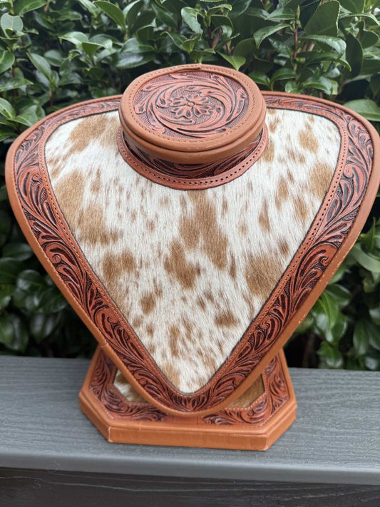Tan tooled leather and tan white cowhide necklace display with floral detailing
