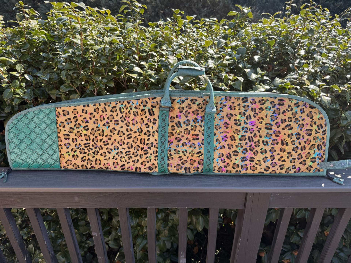 Tooled and cheetah print hide leather rifle case with patchwork design and compartments for travel and storage