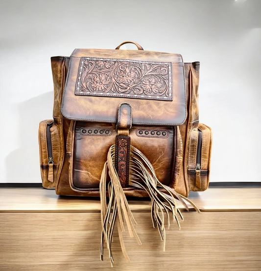 Tooled leather fringe backpack with spacious compartments and artistic design.