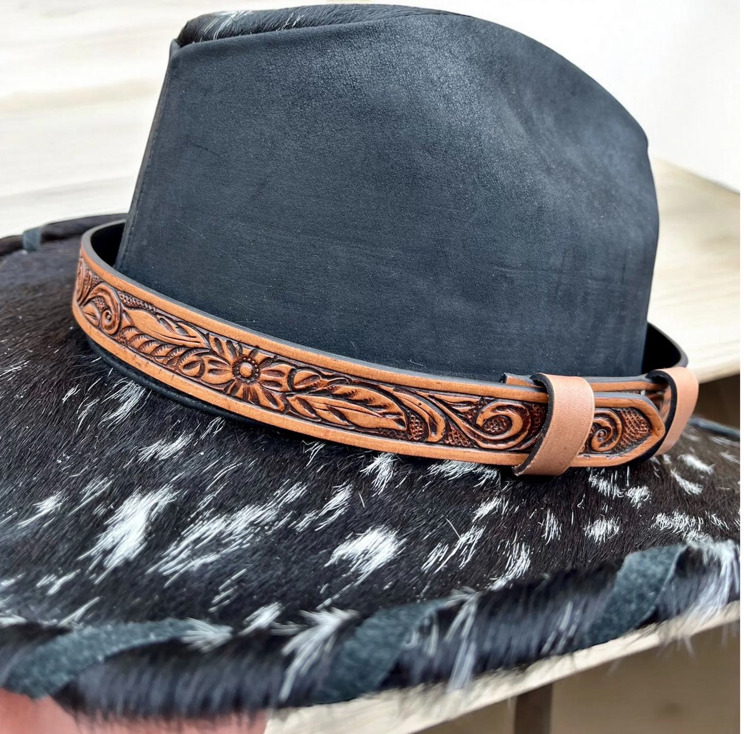 Genuine leather hat band with floral design on a cowboy hat.