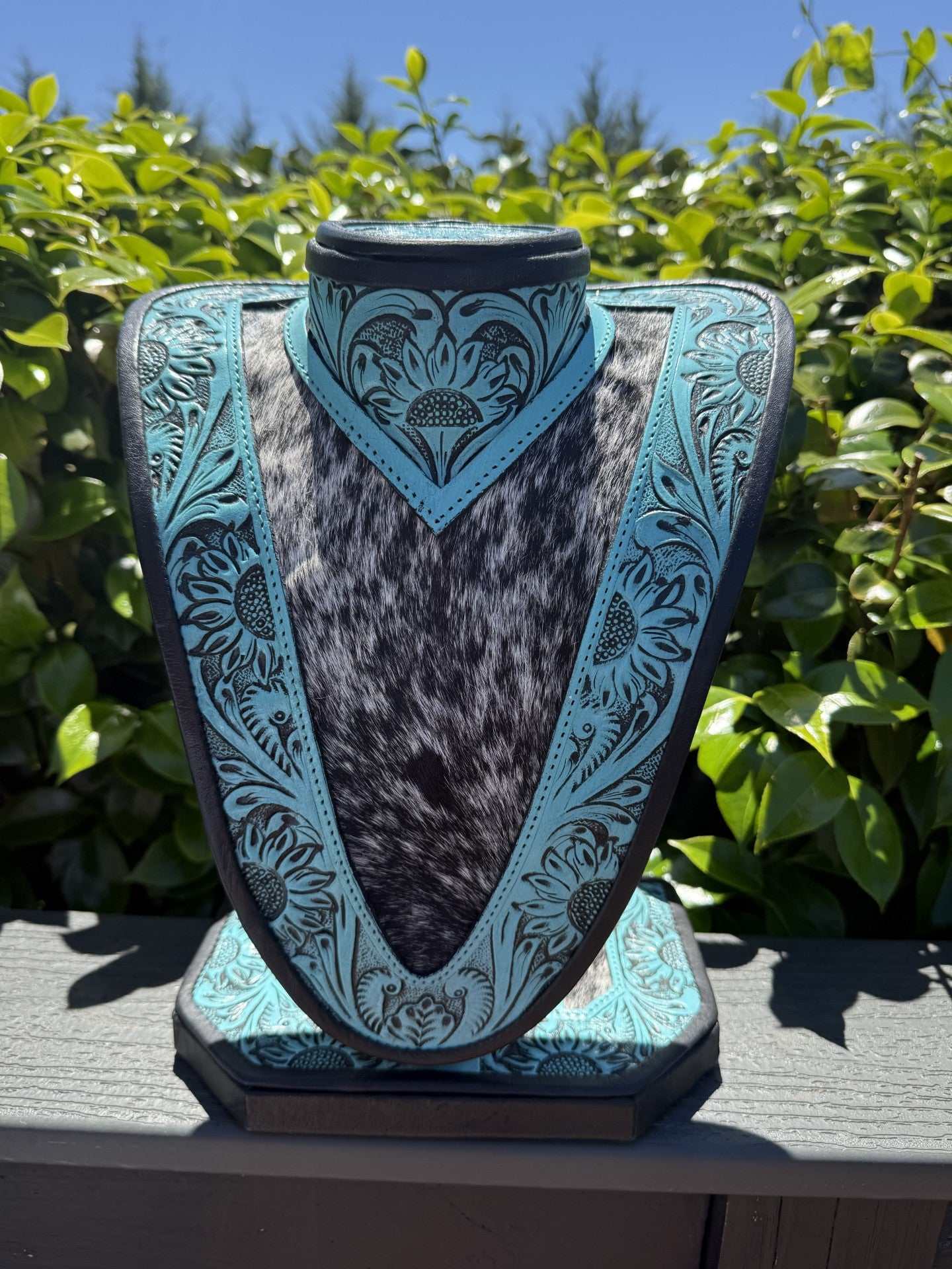 Medium Turquoise tooled Leather Necklace Display with black and white cowhide background