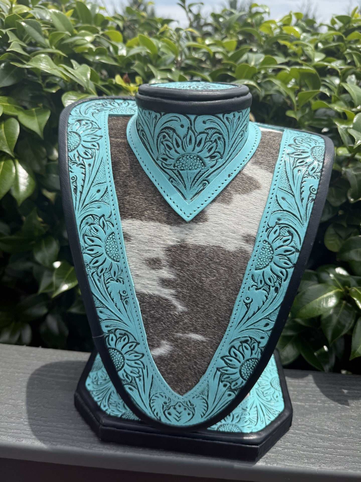 Medium Turquoise tooled Leather Necklace Display with black and white cowhide background