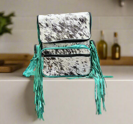 Turquoise cowhide fringe backpack with sleek design and rugged durability, measuring 16x12 inches.