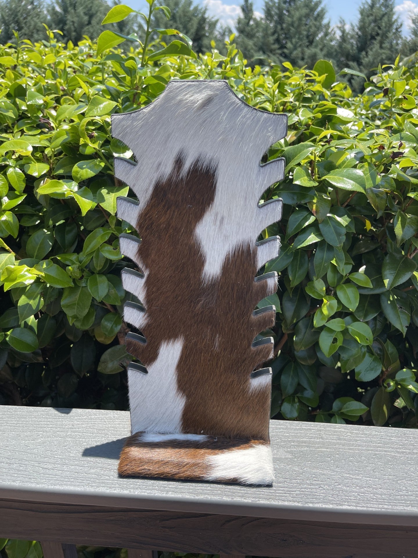 Brown cowhide necklace display stand with slots for organizing jewelry, rustic and sturdy design