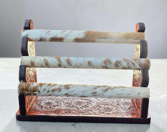 Tooled leather and cowhide bracelet display with rustic western style