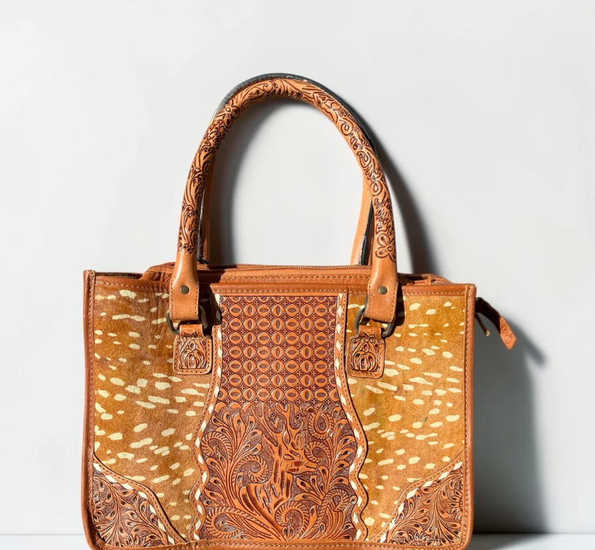 Deer tooled leather tote bag in tan cowhide with white spots and ornate embossed leather panels and handles