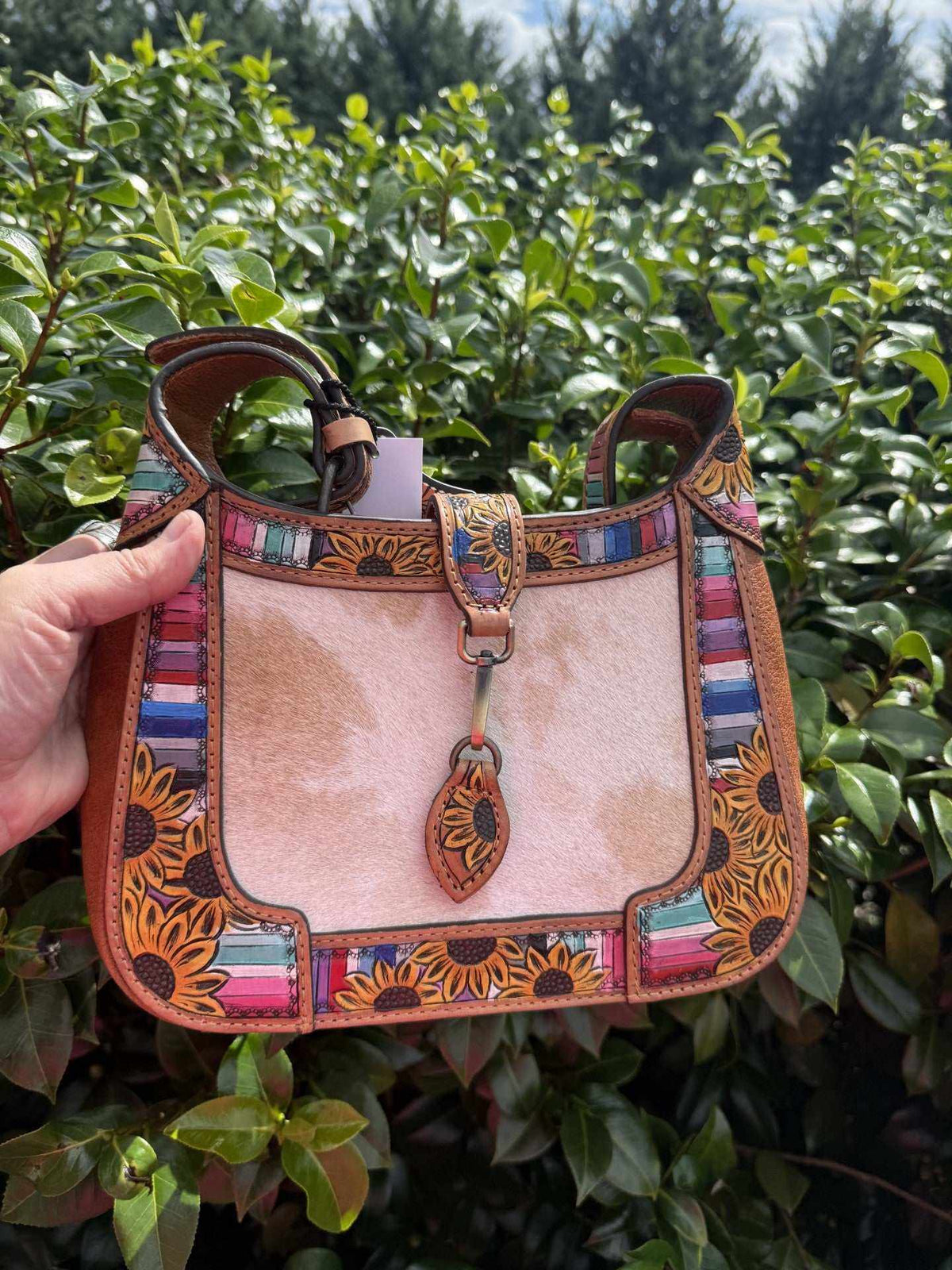 Shoulder bag in natural brown and pink cowhide with colorful striped panels and floral tooled leather trim