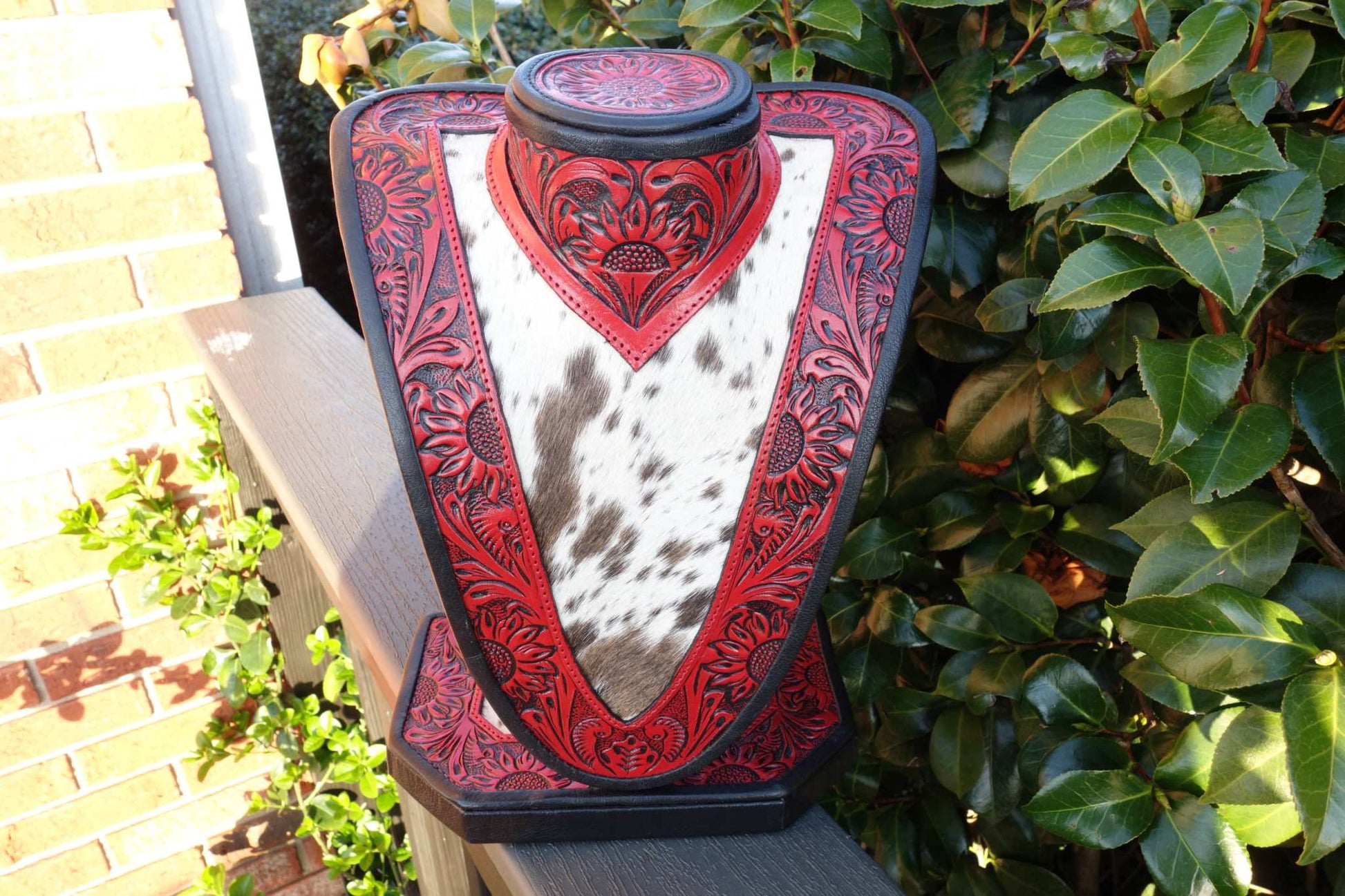 Med Necklace Display in red tooled leather with brown and white cowhide showcasing necklaces