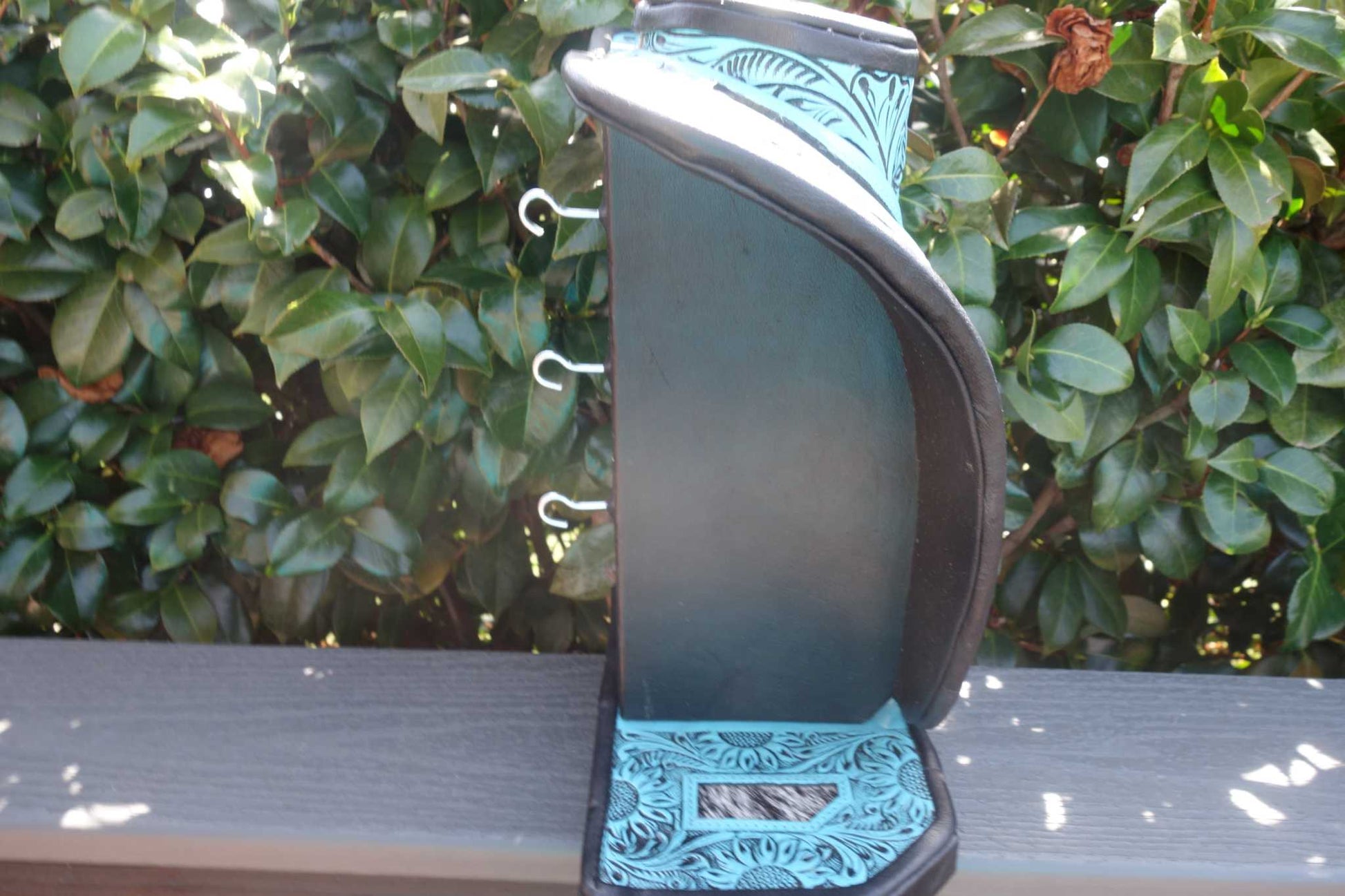 Medium Turquoise tooled Leather Necklace Display with black and white cowhide background
