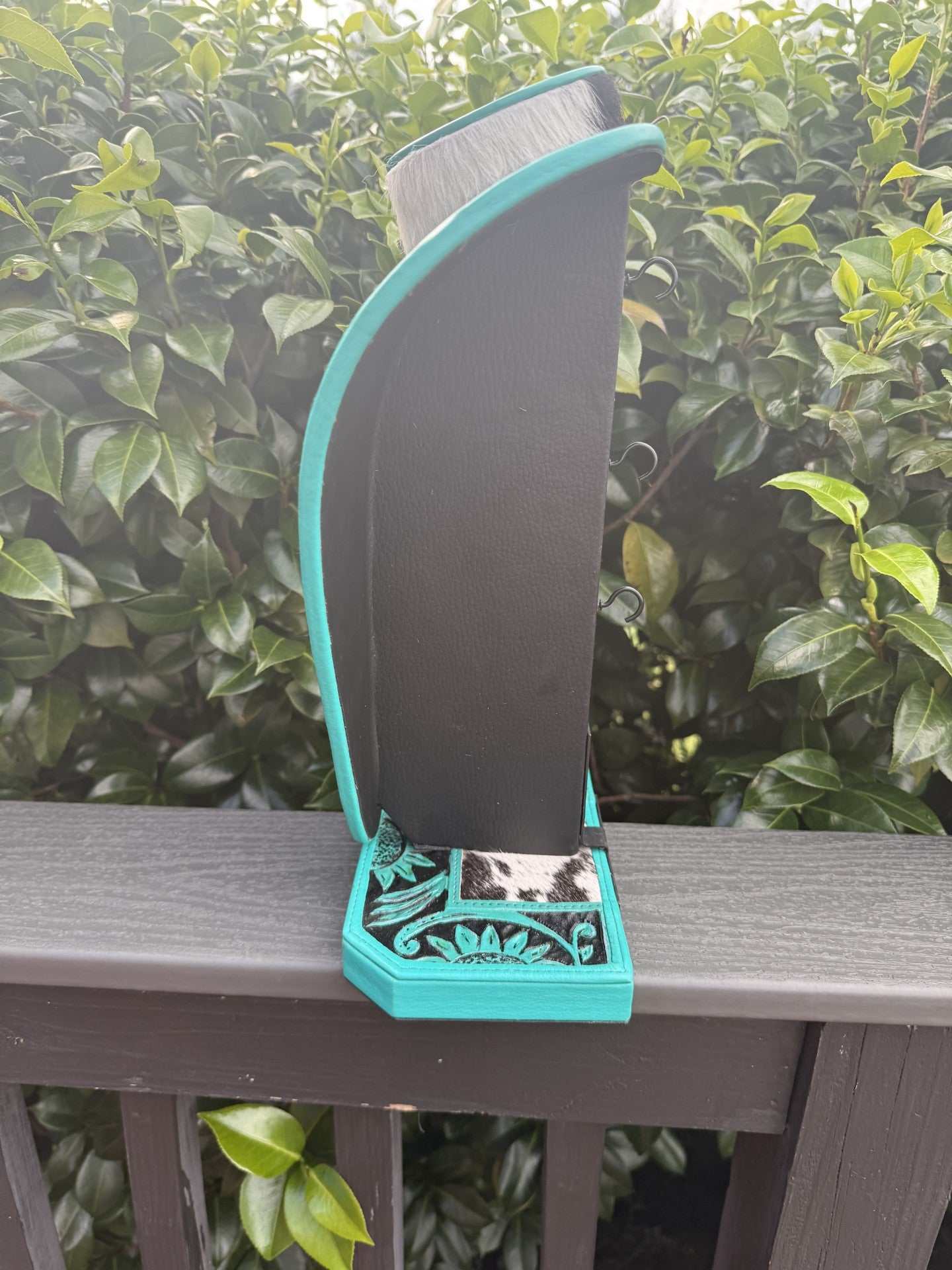 Green turquoise and black leather necklace display with cowhide accents
