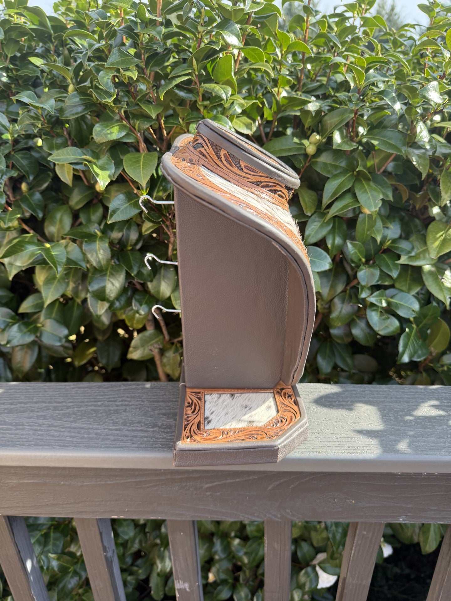 Dark brown tooled leather and cowhide necklace display with intricate detailing, 13x12 inches.