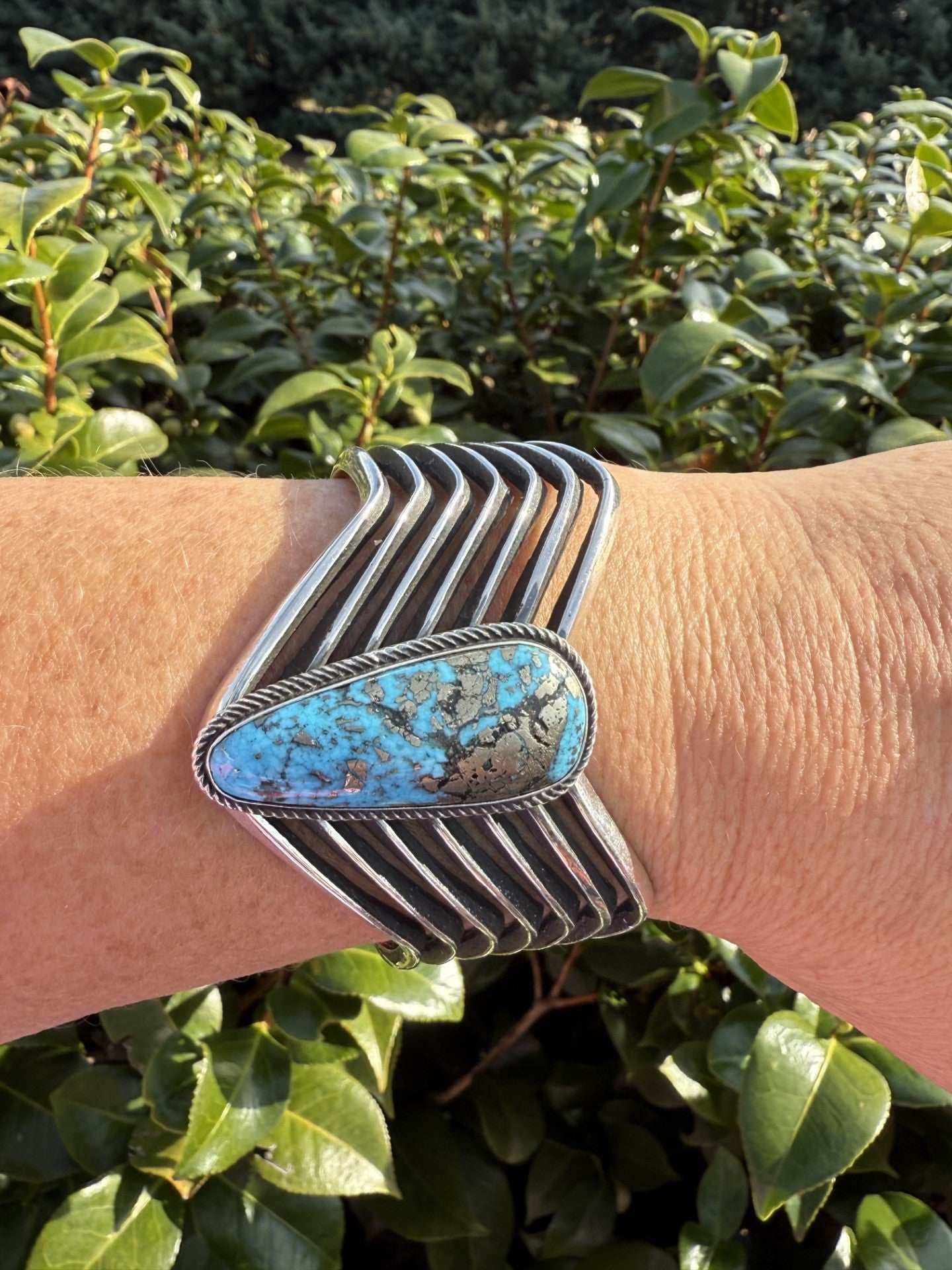 Persian Turquoise Bracelet-cuff by Aaron Anderson with pyrite accents in Navajo style on wrist outdoors