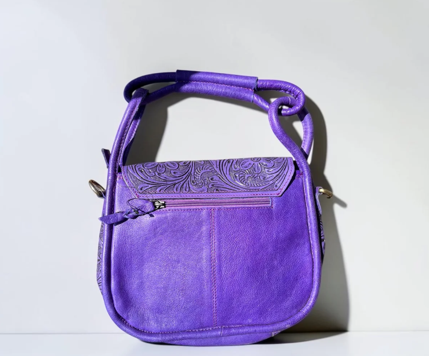 Purple tooled leather shoulder bag in vibrant purple with embossed floral detailing, zip pocket and adjustable strap
