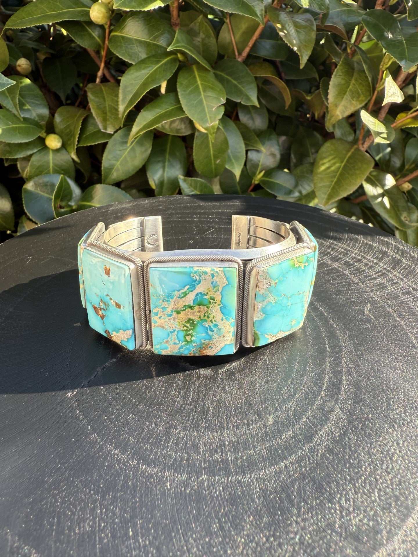 Stunning Sonoran Gold Turquoise cuff with vibrant sky-blue stones set in silver band displayed outdoors