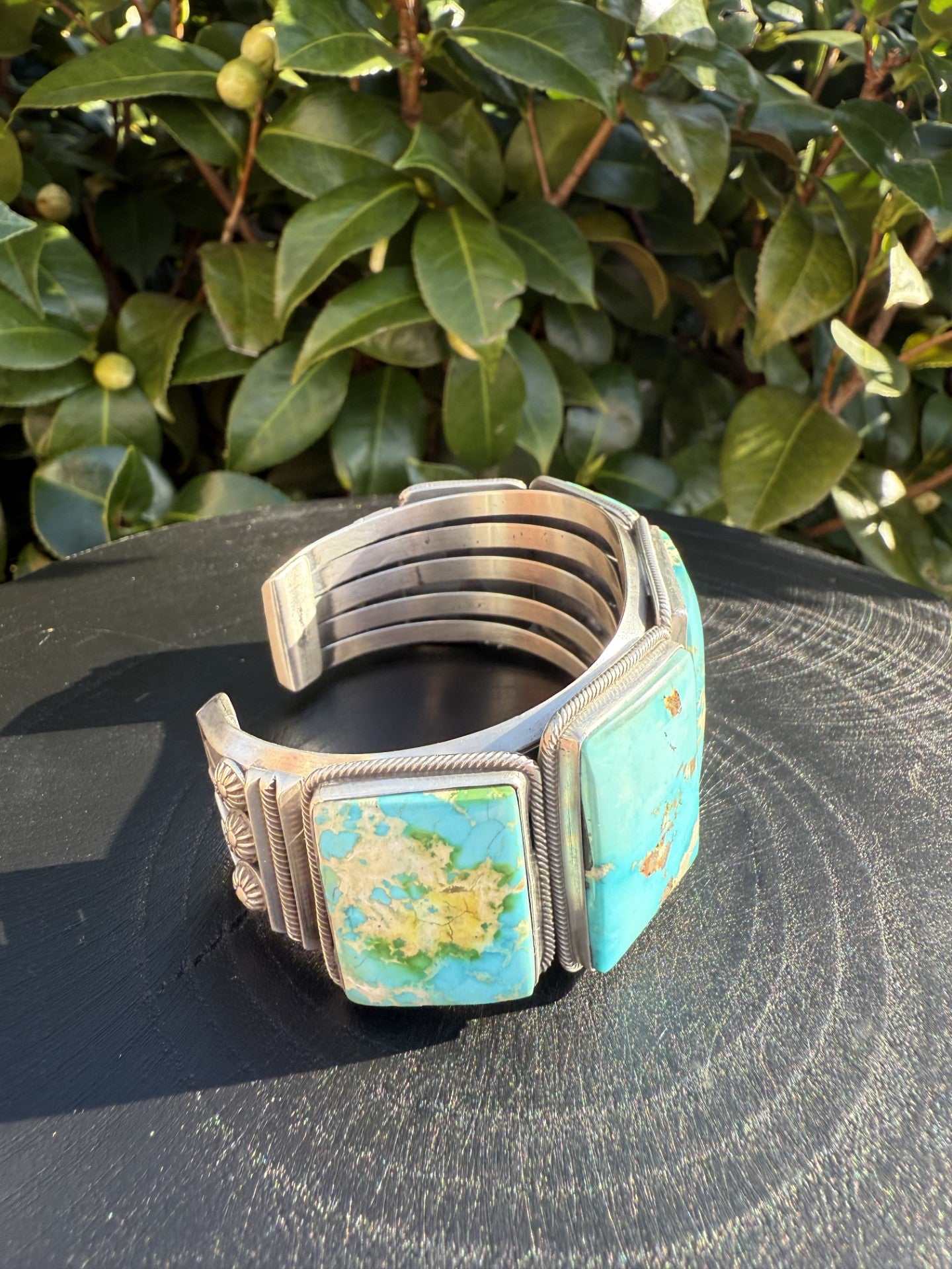 Stunning Sonoran Gold Turquoise cuff with sky-blue stones and silver band on nature background