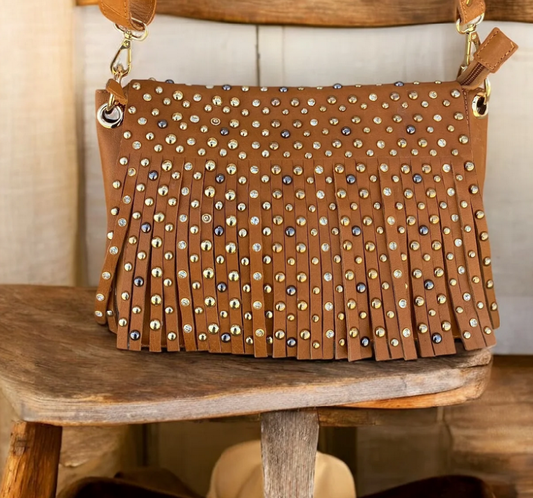 Tan leather studded fringe crossbody bag with adjustable strap.